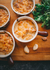 Julienne in portions, Mushrooms with cream and cheese casserole, Restaurant food on a dark background, Top view