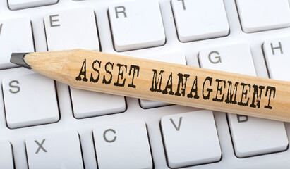 ASSET MANAGEMENT text on pencil on the keyboard background