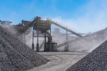 Arid quarry with moving mechanical belt line to separate gravel by size, all wrapped in a cloud of dust. - obrazy, fototapety, plakaty