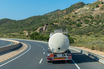 Tank truck with dangerous goods circulating on the highway with hazard labels for toxic product.