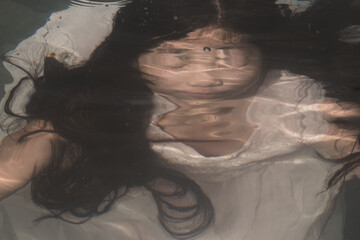 abstract close portrait of a girl in dress under water