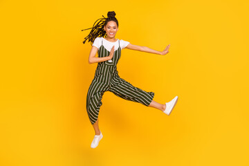 Full length body size of attractive funky cheerful girl jumping dancing doing yoga isolated over bright yellow color background