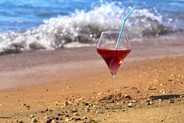 Wine glass with a cocktail by the sea.