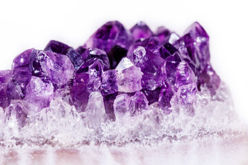 Macro mineral stone purple amethyst in crystals on a white background