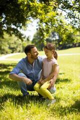 Fototapeta premium Father with daughter having fun on the grass at the park