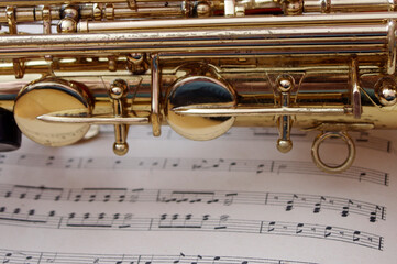 closeup of gold saxophone on sheet music 