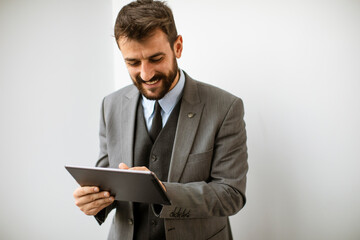 Young modern businessman using digital tablet in the office