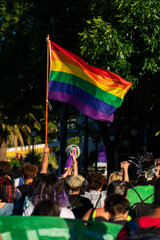people celebrating gay pride raising lgbtq + flag