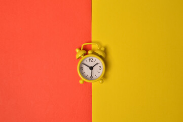 Alarm clock isolated on yellow and red background
