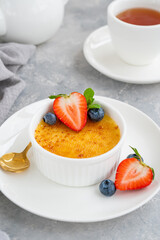 Creme brulee. Traditional French vanilla cream dessert with caramelised sugar and fresh berries on top.