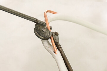 Man hands bends copper pipes by pipe bender. Air conditioner technician hands bends copper pipes by...