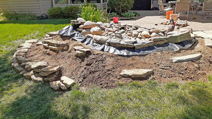 Backyard DIY water feature project being constructed and landscaped, off the patio.