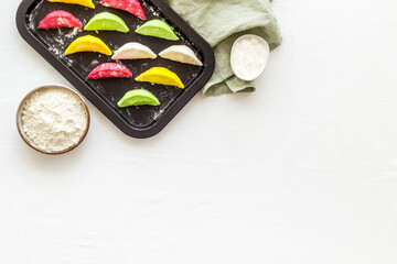 Colorful dumplings tortellini on baking sheet, top view