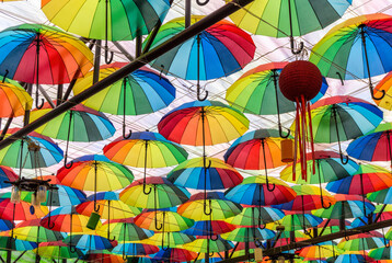 Fototapeta na wymiar Colorful umbrellas on the ceiling of a summer cafe