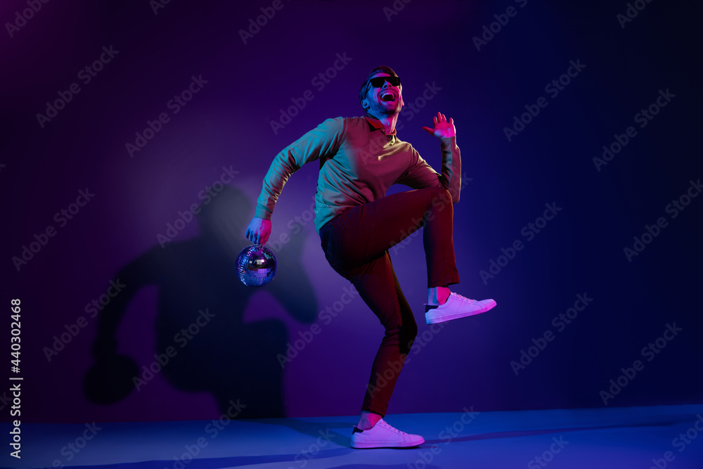 Sticker Full length body size photo man in sunglass dancing on discotheque keeping disco ball isolated on violet color background