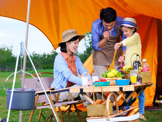 Obraz na płótnie Canvas A happy family of three cooks outdoors