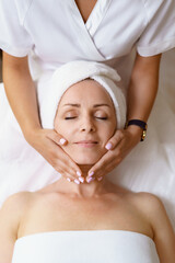 Face massage. Close-up of adult woman getting spa massage treatment at beauty spa salon. Spa skin...
