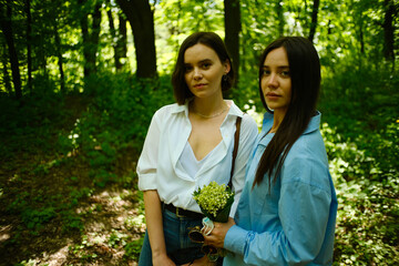 Two beautiful young women outdoor. Dark-haired pretty girls smiling at camera.