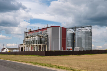 Fototapeta na wymiar Modern Granary elevator and seed cleaning line. Silver silos on agro-processing and manufacturing plant for processing drying cleaning and storage of agricultural products, flour, cereals and grain.