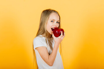 Beautiful blonde girl with red apple in studio