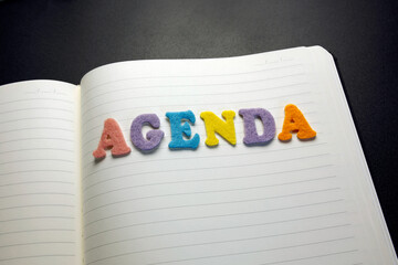 agenda word made with colorful felt letters on notebook