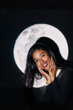 Hispanic woman under moon projection
