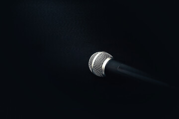professional microphone on a black background. sound and speaker concept. microphone and text in black