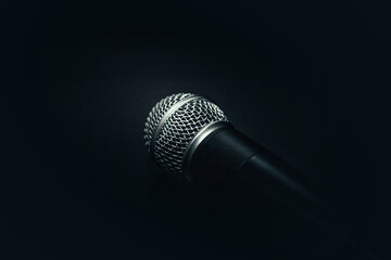 microphone on a black background. black texture with a microphone. music and sound concept - obrazy, fototapety, plakaty