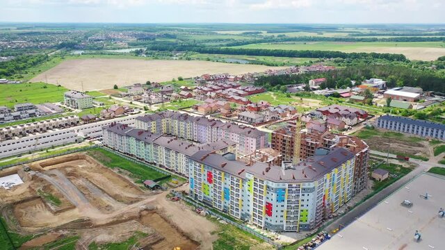 Modern residential complex in the countryside. Colorful high-rise buildings on a construction site. New microdistrict is building. Aerial view.