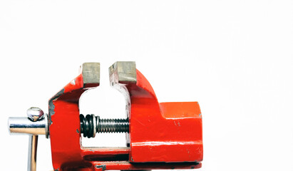 close-up view of a red steel bench vise isolated on a white background