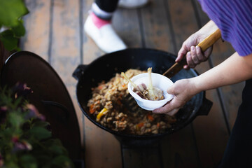 woman puts pilaf on a plate