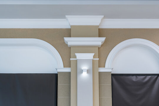 Detail of corner ceiling with intricate crown molding on column with spot light