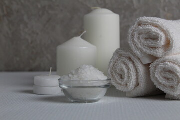 Obraz na płótnie Canvas Spa salon, spa treatments. Towels, candles salt to wrap on a gray white background with a place for text and with a copyspace