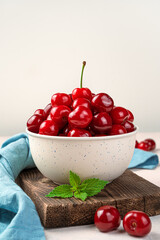 Beige plate with large ripe cherries. Side view, vertical.