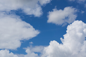Naklejka na ściany i meble Cumulus fluffy white big clouds on the blue sky