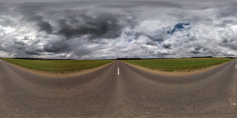 Full spherical seamless panorama 360 degree angle view on no traffic old asphalt road among fields...