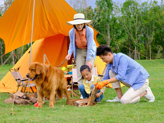 Happy family of three and dog camping out