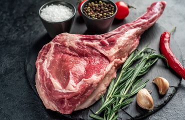 Raw tomahawk steak on stone background