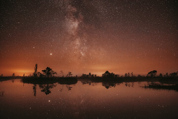 Fototapeta na wymiar Swamp Bog Marsh Wetland Lake Nature Night Landscape. Night Starry Sky Milky Way Galaxy With Glowing Stars And Moon. Nature Night Sky Reflection In Water. Yelnya Swamp In Belarus