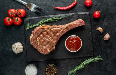 Obraz na płótnie Canvas Grilled tomahawk steak on stone background