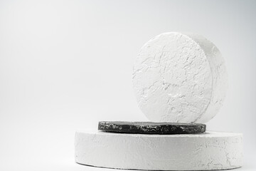 White and black round pedestal podium. Abstract cement pedestal by spotlights on white background
