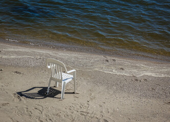 Lone plastic chair on the beach on Lake Winnipeg, Canada