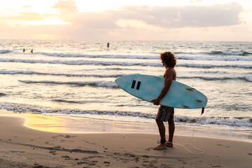 Fototapeta na wymiar Young caucasian man get up early to doing surf at sunrise