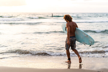 Young caucasian man get up early to  doing surf at sunrise