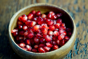 view of pomegranate seeds on a wooden bowl