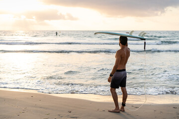 Young caucasian man get up early to  doing surf at sunrise