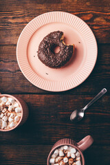 Chocolate Donut with a Bite and Mugs of Hot Chocolate
