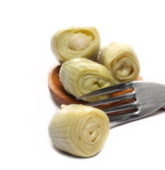 Artichoke with fork and wooden spoon isolated on white background