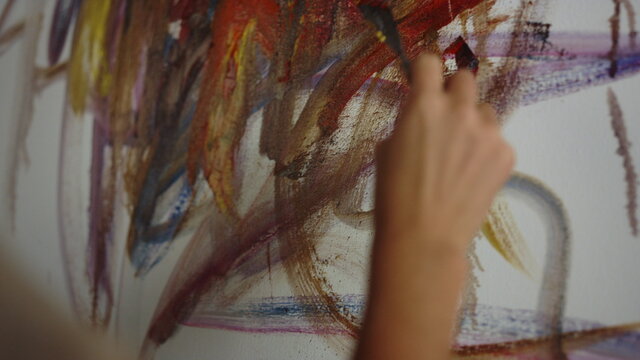 Unrecognizable woman drawing in studio. Painter working on artwork indoors.