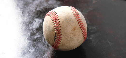 Old torn baseball seams of ball on rugged texture background with copy space.